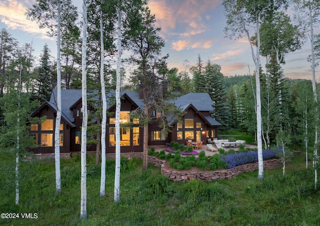 back house at dusk with a patio area