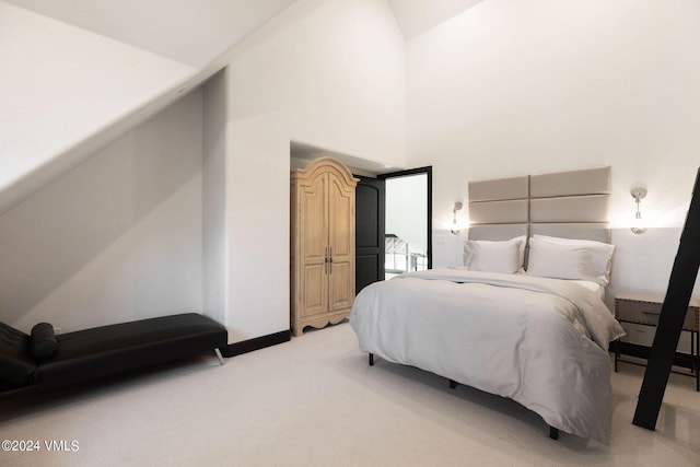 carpeted bedroom featuring a towering ceiling