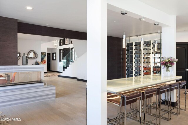 wine area featuring beamed ceiling and light wood-type flooring