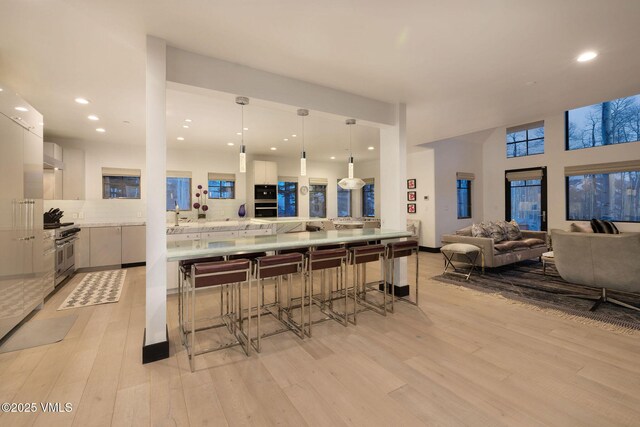 47 Woodviolet Rd, Avon, CO 81620 - kitchen featuring modern cabinets, a breakfast bar, wall chimney exhaust hood, and white cabinets