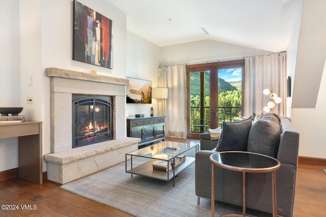 living room with hardwood / wood-style flooring, a fireplace, and vaulted ceiling