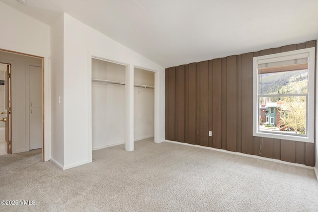 4255 Columbine Way Unit 16, Vail, CO 81657 - unfurnished bedroom with carpet, two closets, vaulted ceiling, wood walls, and baseboards
