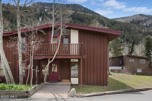 4255 Columbine Way Unit 16, Vail, CO 81657 - view of front of house with a mountain view, a chimney, and a front lawn