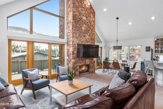 tiled living room with a wealth of natural light, a stone fireplace, and high vaulted ceiling