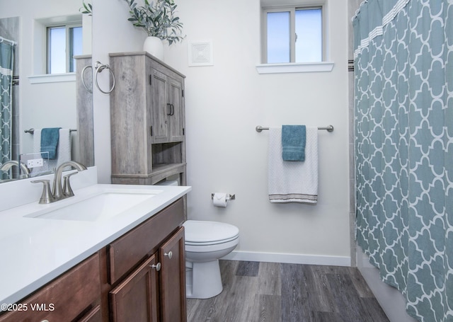 full bath featuring curtained shower, toilet, wood finished floors, vanity, and baseboards