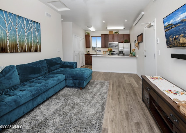 living room with visible vents and wood finished floors