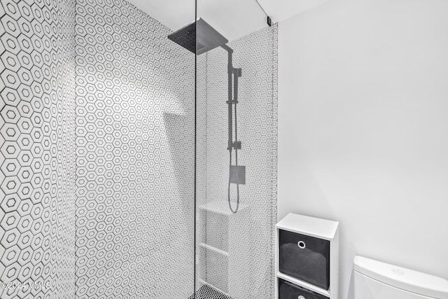 details featuring a tile shower and toilet