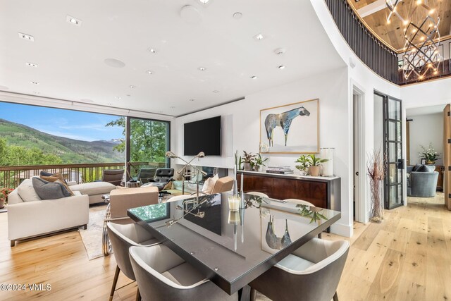 dining room featuring floor to ceiling windows, a notable chandelier, and light hardwood / wood-style flooring