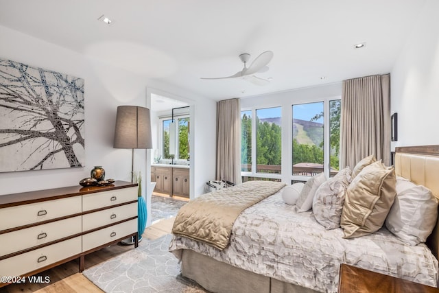 bedroom featuring ceiling fan, ensuite bathroom, and light hardwood / wood-style floors