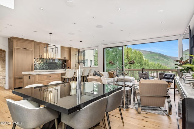 dining area featuring floor to ceiling windows, sink, and light hardwood / wood-style flooring