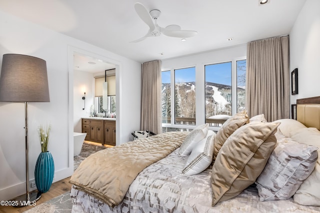 bedroom featuring ensuite bathroom, sink, a mountain view, hardwood / wood-style flooring, and ceiling fan