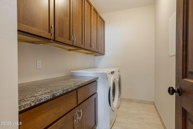 washroom featuring cabinet space, baseboards, and independent washer and dryer