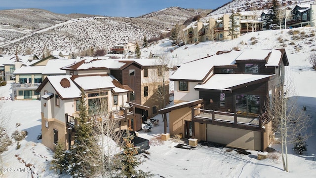 snowy aerial view featuring a residential view and a mountain view