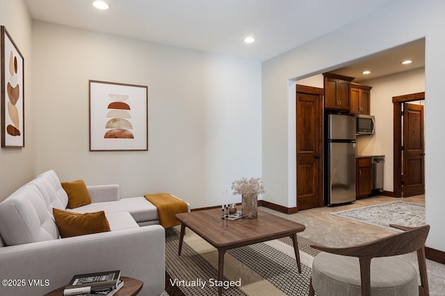 living room with recessed lighting, light carpet, and baseboards