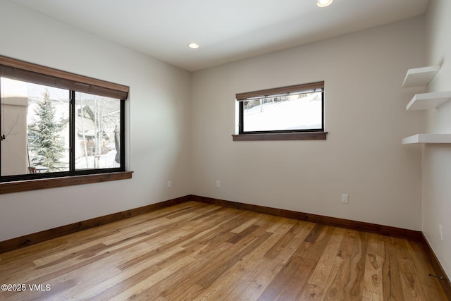 spare room with light wood-style flooring, baseboards, and recessed lighting