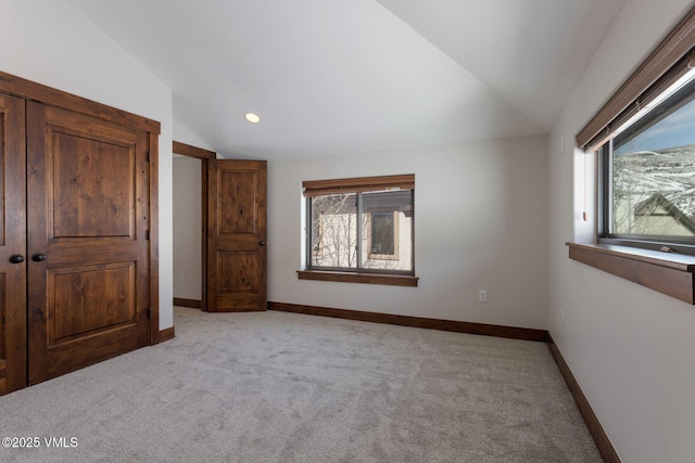 unfurnished bedroom featuring recessed lighting, baseboards, vaulted ceiling, and light colored carpet