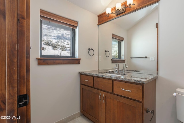 bathroom featuring toilet, baseboards, lofted ceiling, and vanity