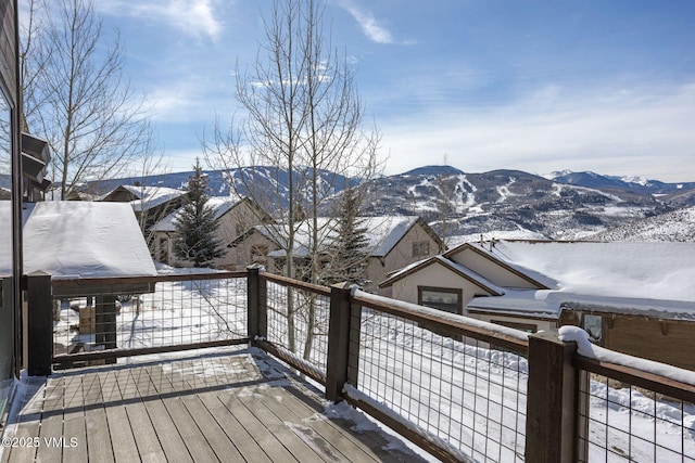 snow covered deck with a mountain view