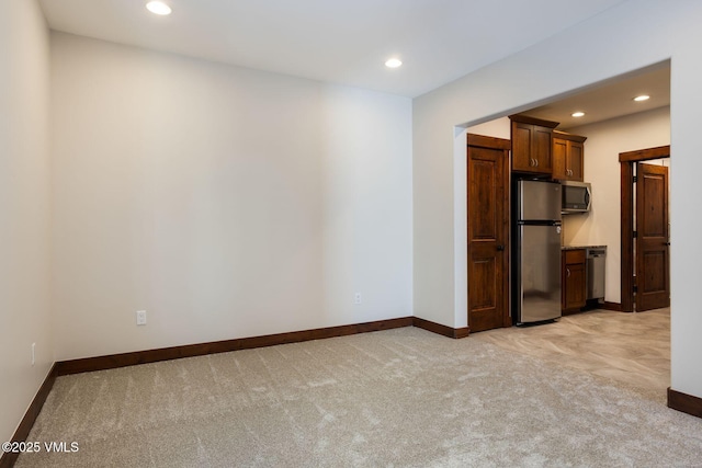 spare room with light carpet, baseboards, and recessed lighting