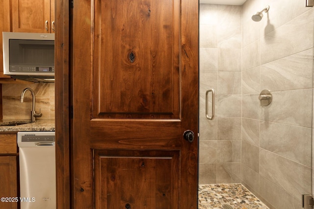 full bath with a sink and a shower stall