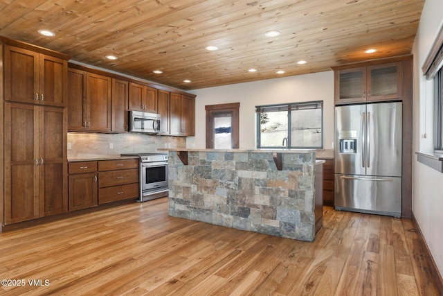 kitchen featuring decorative backsplash, wooden ceiling, light wood-style flooring, glass insert cabinets, and stainless steel appliances