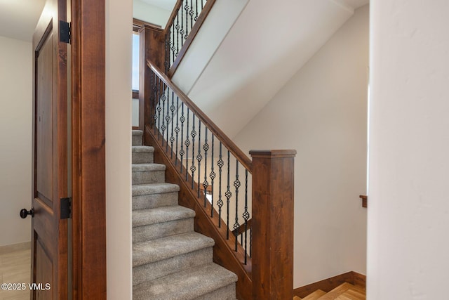 staircase with baseboards and wood finished floors