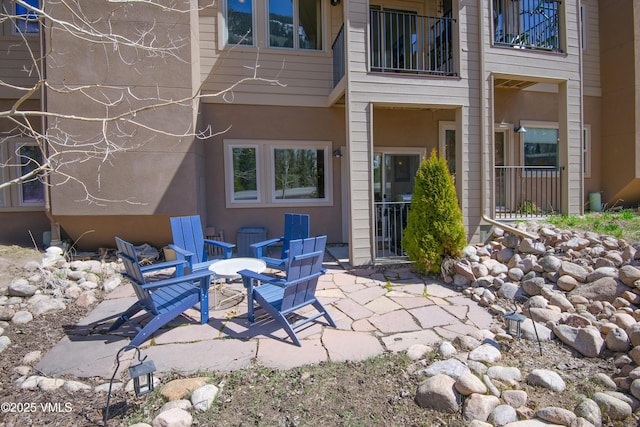 back of house featuring a balcony and a patio area