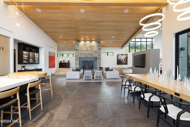 dining room featuring a towering ceiling and wooden ceiling