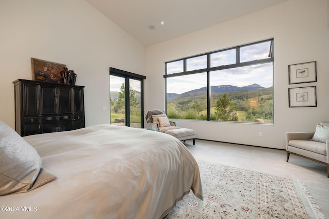 bedroom with a mountain view, access to outside, and high vaulted ceiling