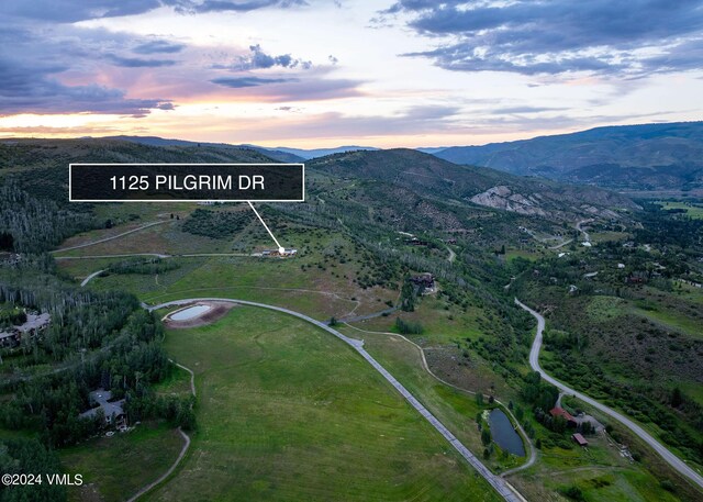 aerial view at dusk featuring a mountain view