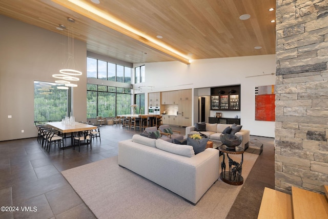 living room featuring wood ceiling, a chandelier, and a high ceiling