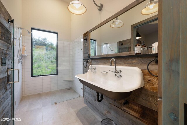 bathroom with tile walls, sink, and walk in shower