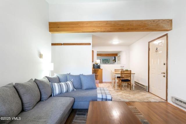 living room featuring a baseboard radiator, beamed ceiling, and wood finished floors