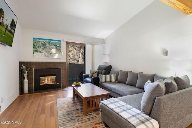 living room with wood finished floors and a tile fireplace