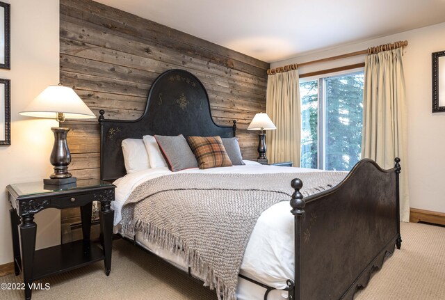 carpeted bedroom featuring wood walls