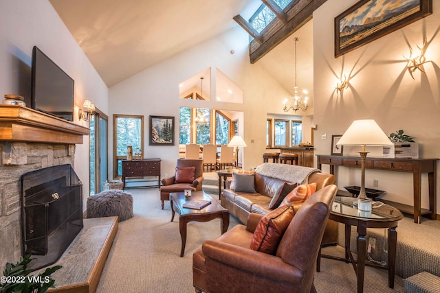 living room featuring a stone fireplace, high vaulted ceiling, a skylight, carpet floors, and a notable chandelier