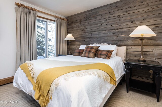 bedroom featuring carpet flooring and wood walls