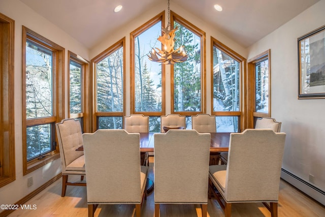 dining area with light hardwood / wood-style flooring, a notable chandelier, and a baseboard radiator