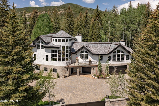 1531 Lake Creek Rd, Edwards, CO 81632 - rear view of property with a chimney, a view of trees, a garage, and stone siding