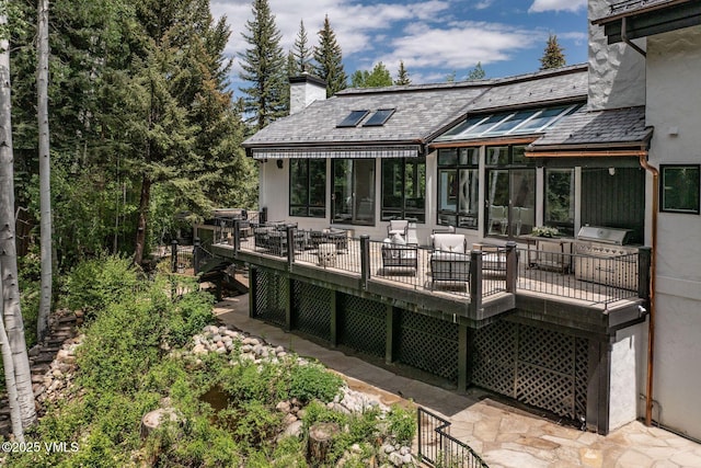 1531 Lake Creek Rd, Edwards, CO 81632 - back of house with a high end roof, a chimney, a wooden deck, and stucco siding