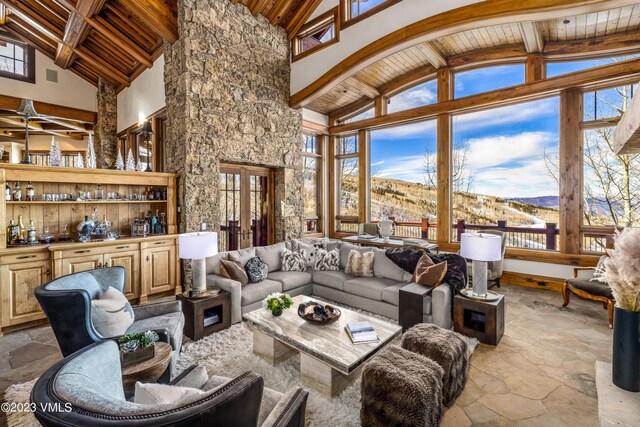 living room with a mountain view, lofted ceiling with beams, wooden ceiling, and french doors