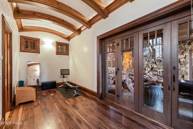 interior space with lofted ceiling with beams, dark wood-type flooring, and french doors