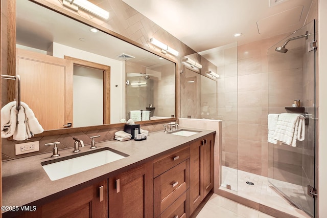 bathroom with a stall shower, a sink, and visible vents