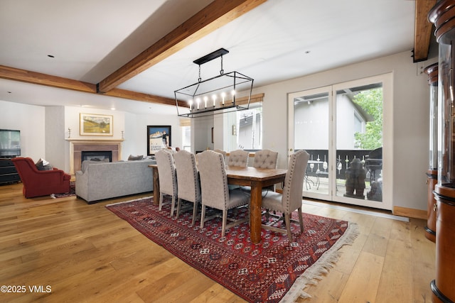 66 Arrowhead Cir Unit 13, Edwards, CO 81632 - dining room with beam ceiling, light wood-style flooring, a chandelier, and a fireplace