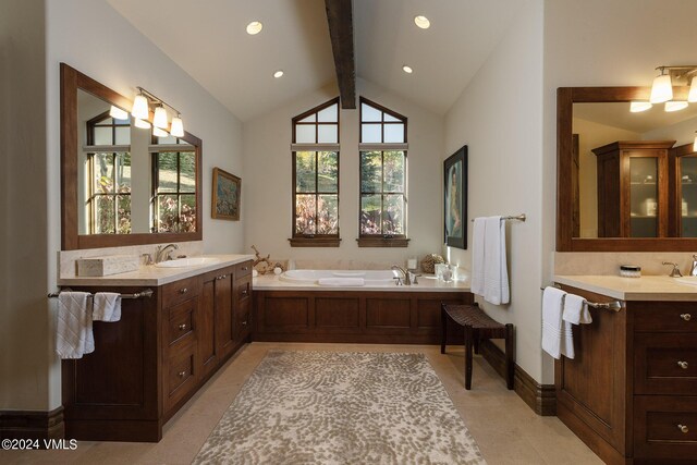 bathroom with lofted ceiling with beams, vanity, and a washtub