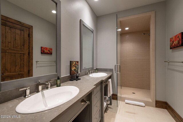 bathroom featuring vanity, tile patterned floors, and tiled shower