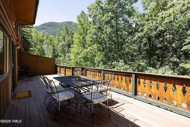 3115 Booth Falls Ct Unit B, Vail, CO 81657 - deck with outdoor dining space, a mountain view, and a view of trees