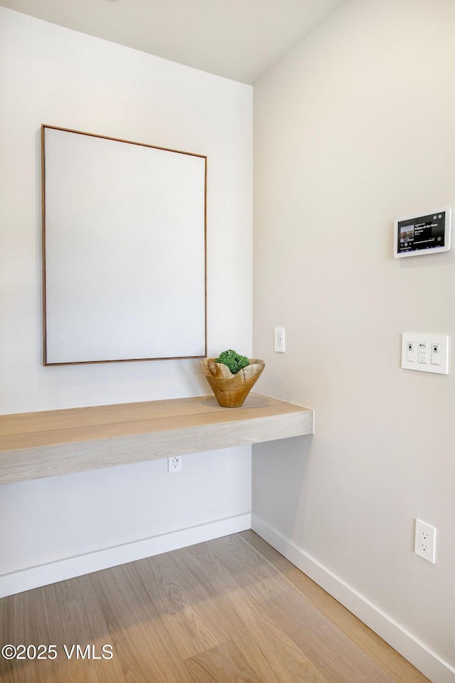 interior space featuring baseboards and wood finished floors