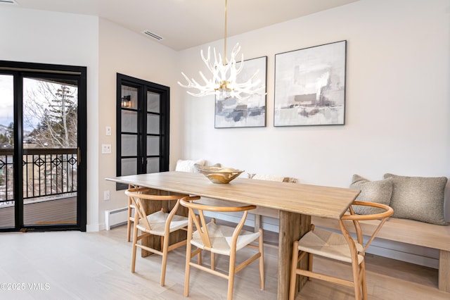 dining space with visible vents, baseboards, breakfast area, an inviting chandelier, and a baseboard heating unit