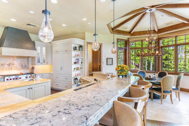 46 Jasmine, Avon, CO 81620 - kitchen with custom range hood, a chandelier, healthy amount of natural light, light stone counters, and recessed lighting